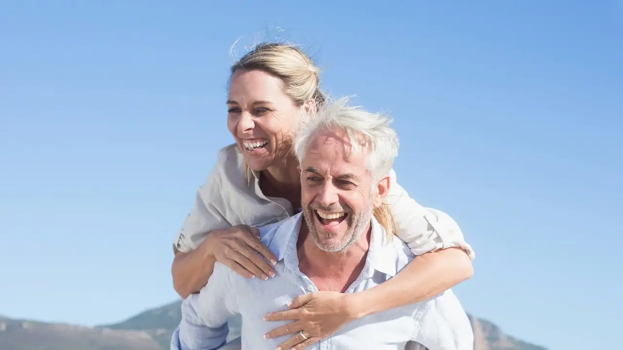 A couple laughing outdoors — the homepage photograph of Bjorklund Dental Designs, Wayzata, Minnesota.